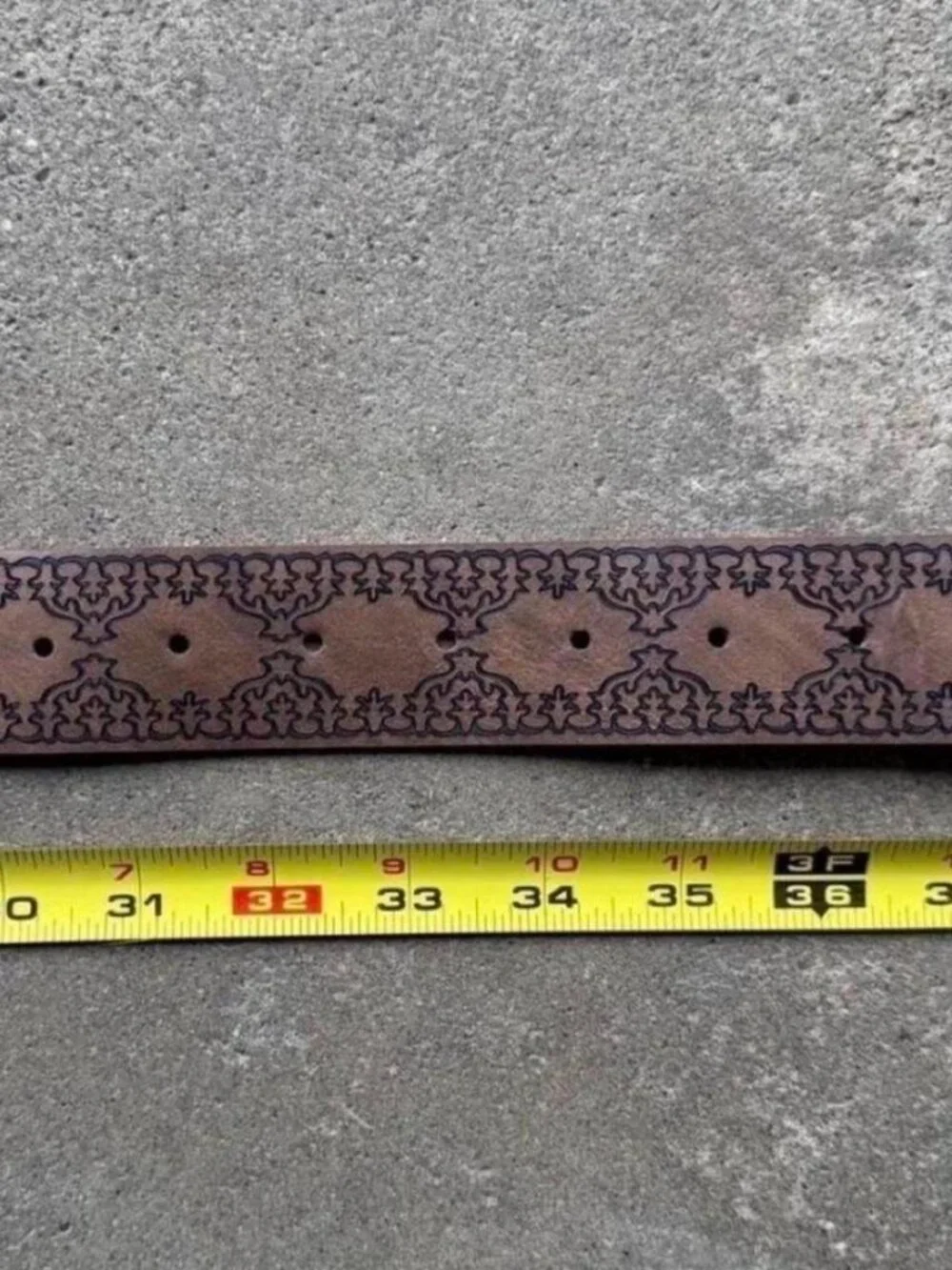 brown belt with embossed floral and scrollwork design